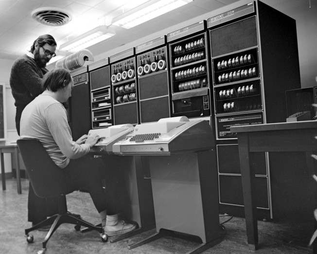 Кен Томпсон, изображённый вместе с Деннисом на этом знаменитом фото 1972 года, сам по себе легендарная личность, но — ирония судьбы, не иначе — известен ещё меньше, чем его коллега по проекту UNIX. Ему принадлежит авторство или соавторство идеи регулярных выражений и редакторов QED/ed, кодировки UTF-8, языка программирования Go (созданном им уже в Google). Он же помог построить и Belle — многократного мирового чемпиона по шахматам среди компьютеров.
