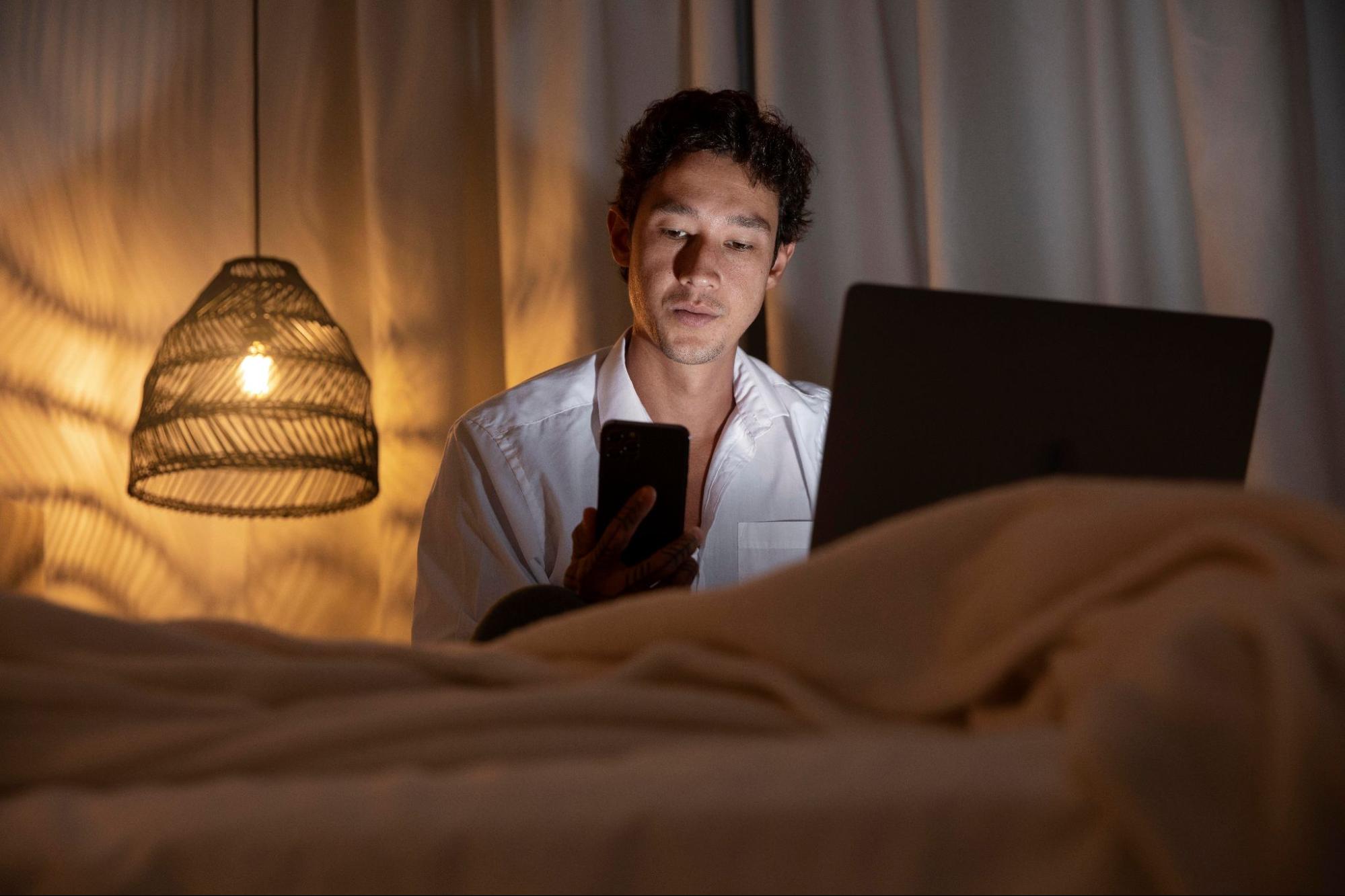 Человек вечером смотрит в смартфон // Источник: freepik