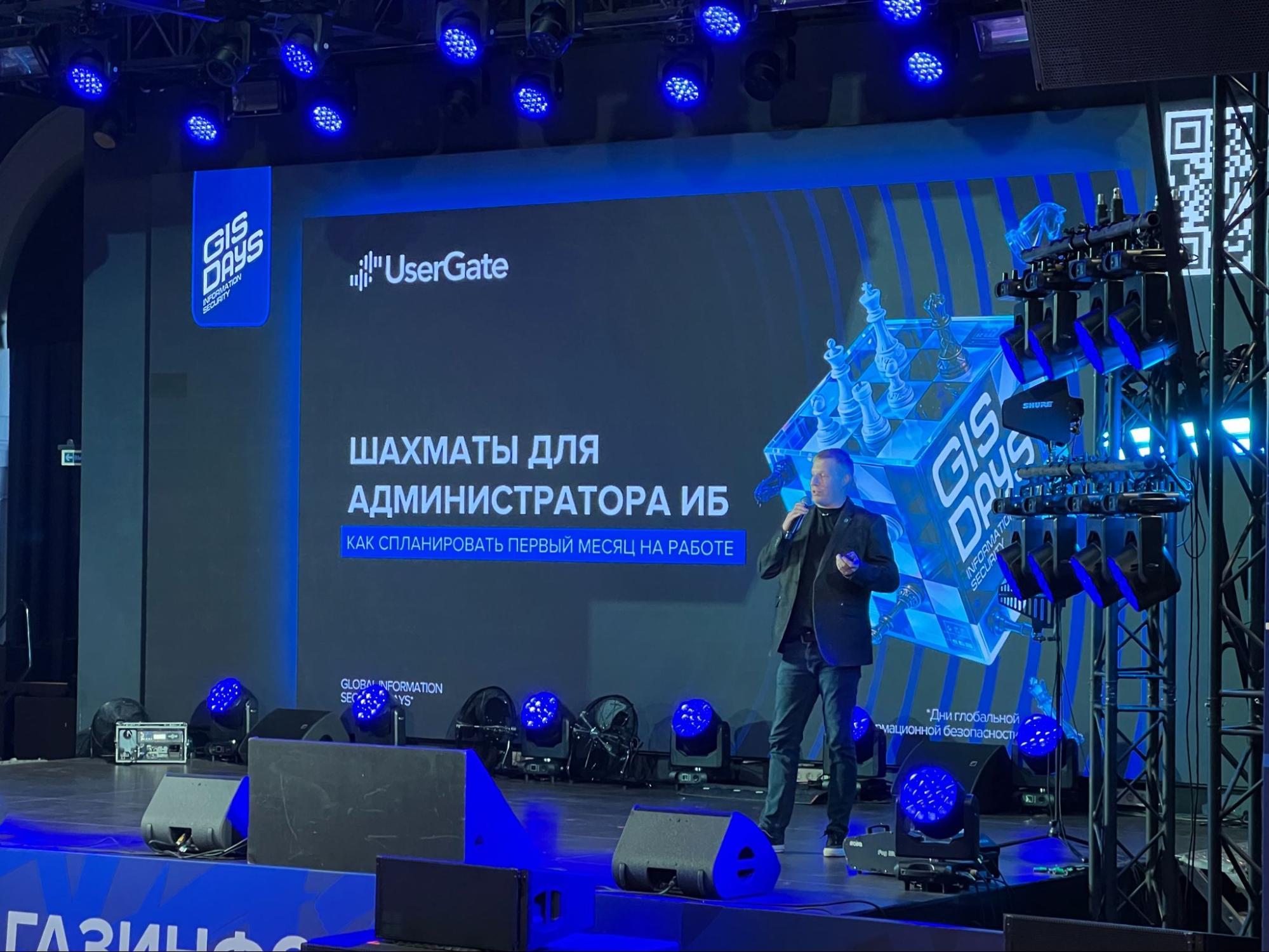 Спикер представляет доклад «Шахматы для администратора ИБ» на сцене с логотипом UserGate