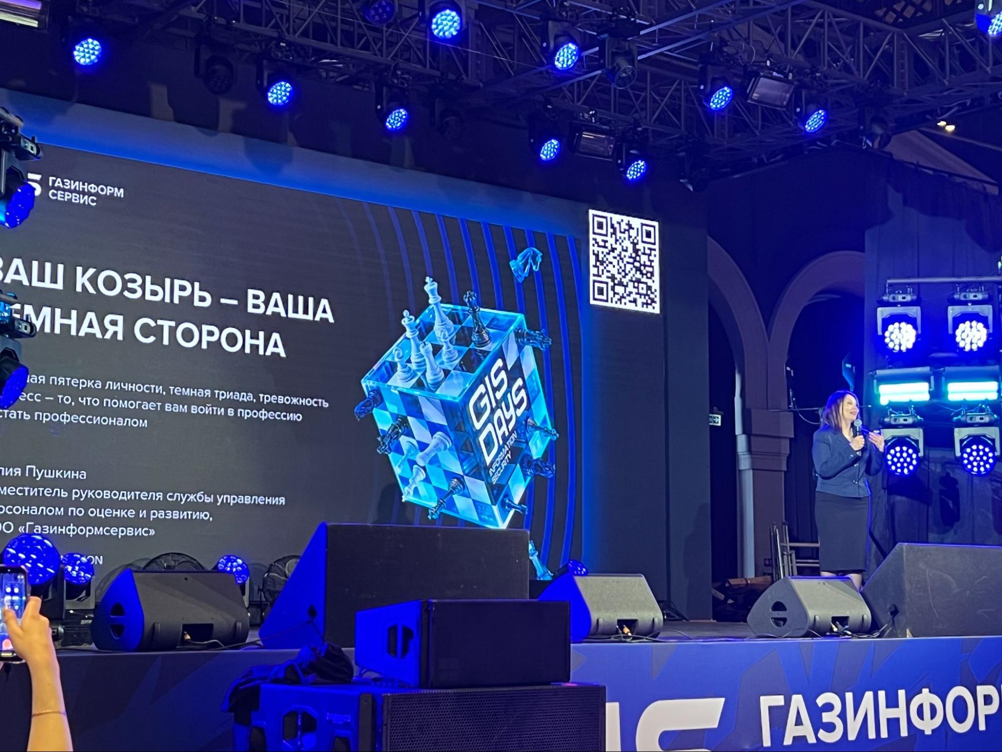 Спикер выступает с докладом «Ваш козырь — ваша темная сторона», зритель снимает сцену на телефон