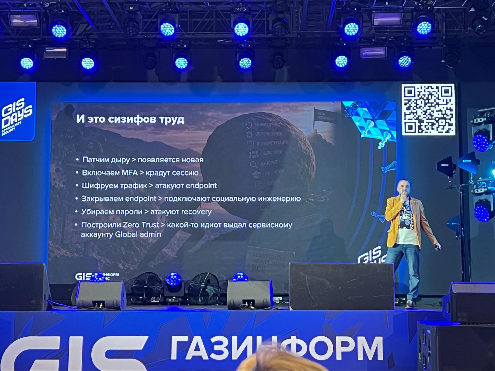 Спикер на сцене GIS STUDENT DAY 2026 у слайда «И это сизифов труд» о работе защитников