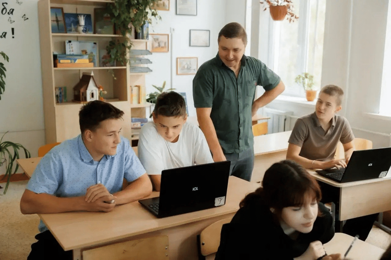 Практическое занятие: преподаватель помогает ученикам с заданием на ноутбуках