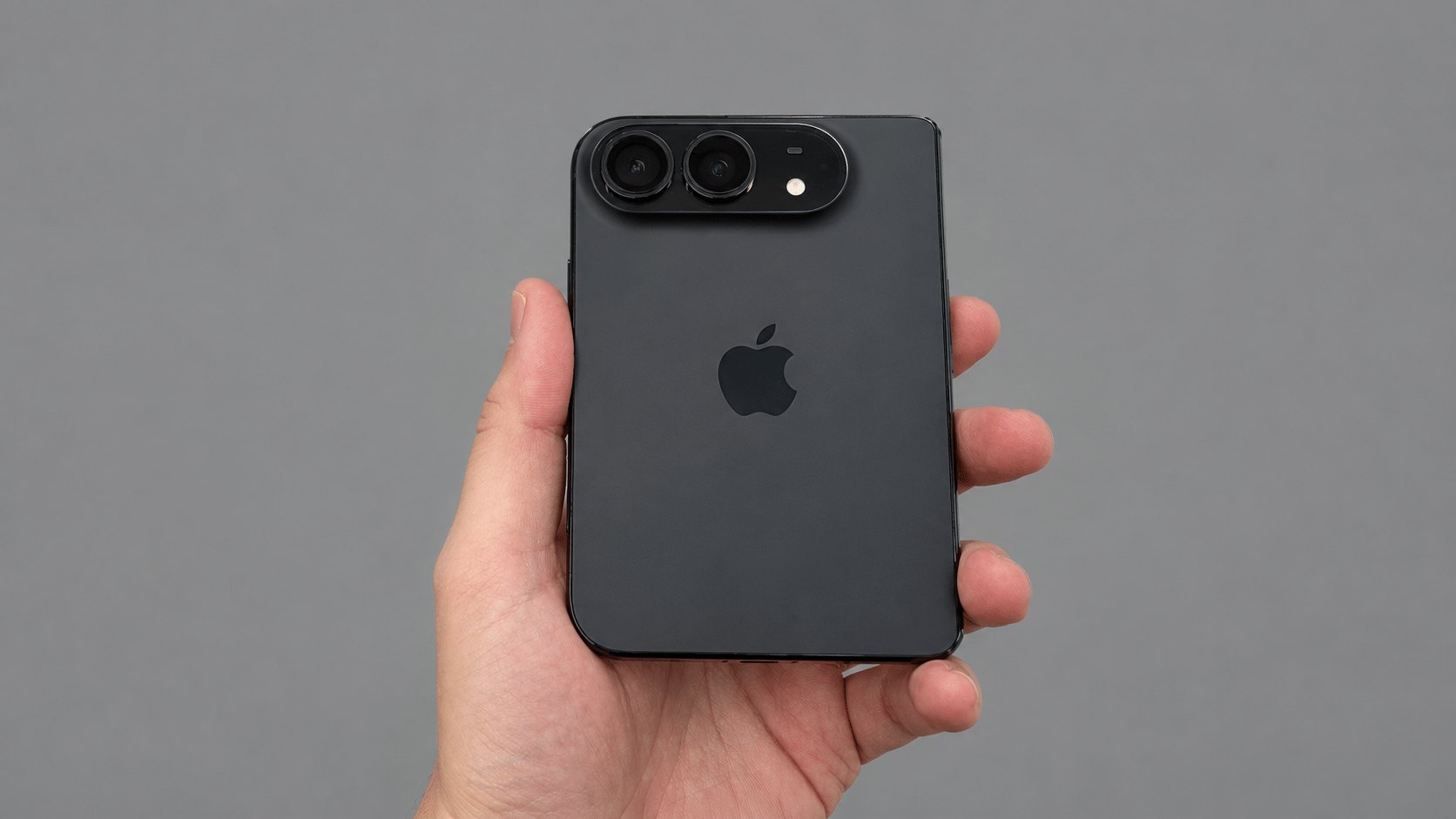 Сложенный iPhone Duo в руке: задняя панель с блоком из двух камер