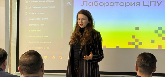 Женщина выступает перед проекционным экраном с надписью «Лаборатория ЦПУ»