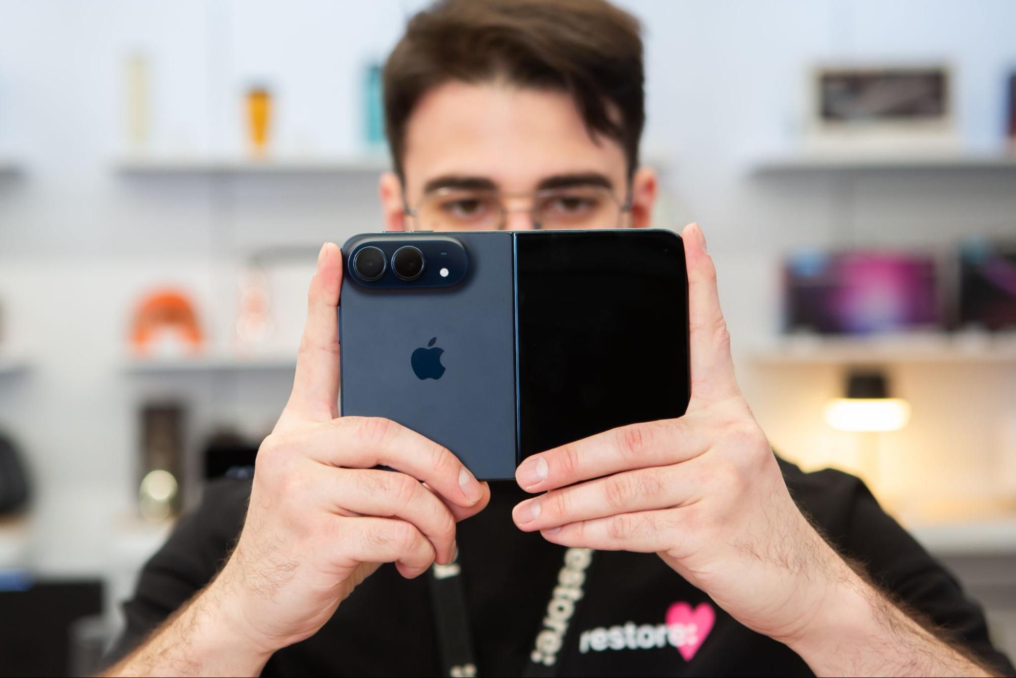 iPhone Duo в руках сотрудника restore: — сложенный складной смартфон с двумя камерами