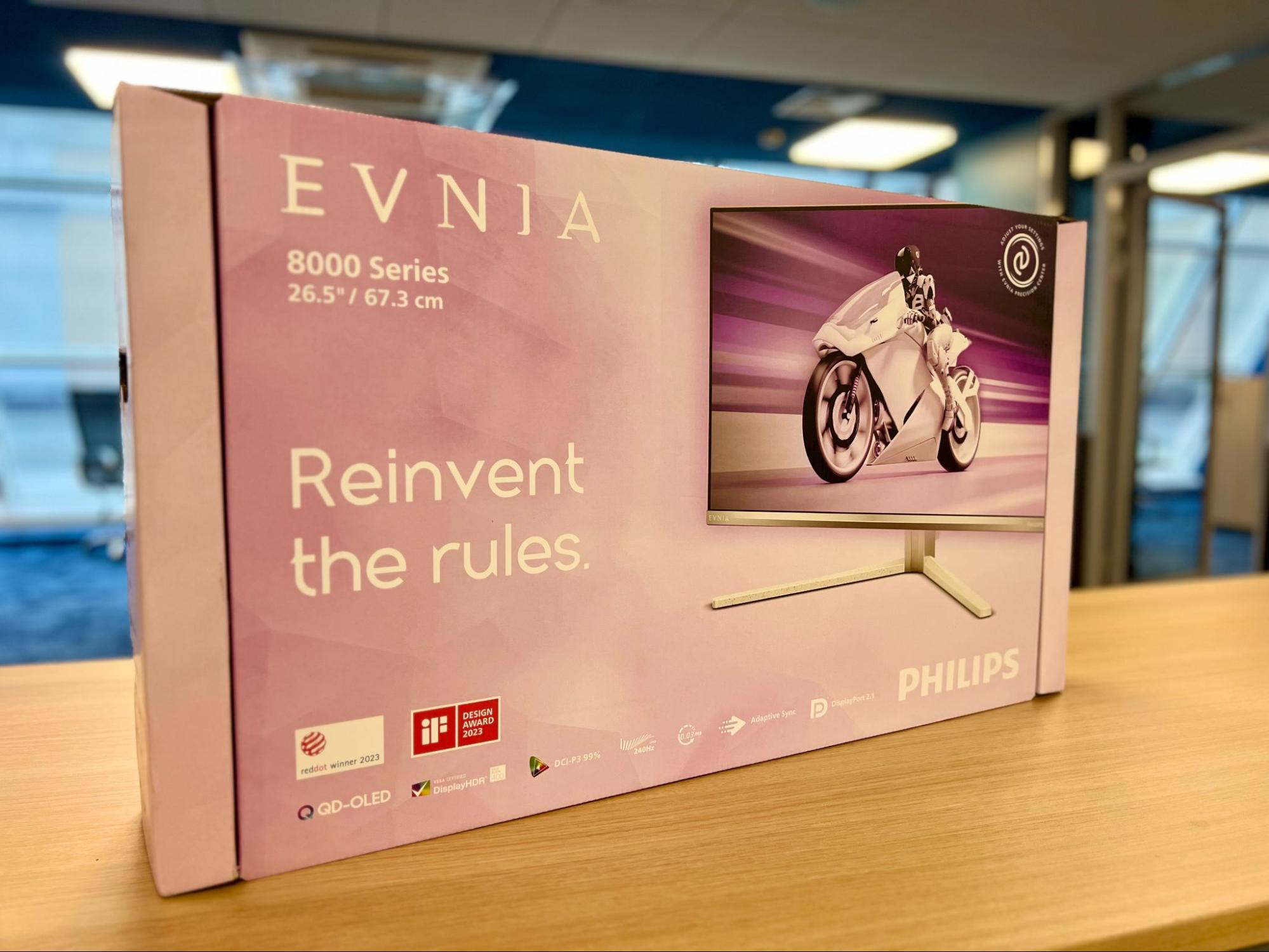 Розовая коробка монитора Philips Evnia 27M2N8800 серии Evnia 8000 на столе