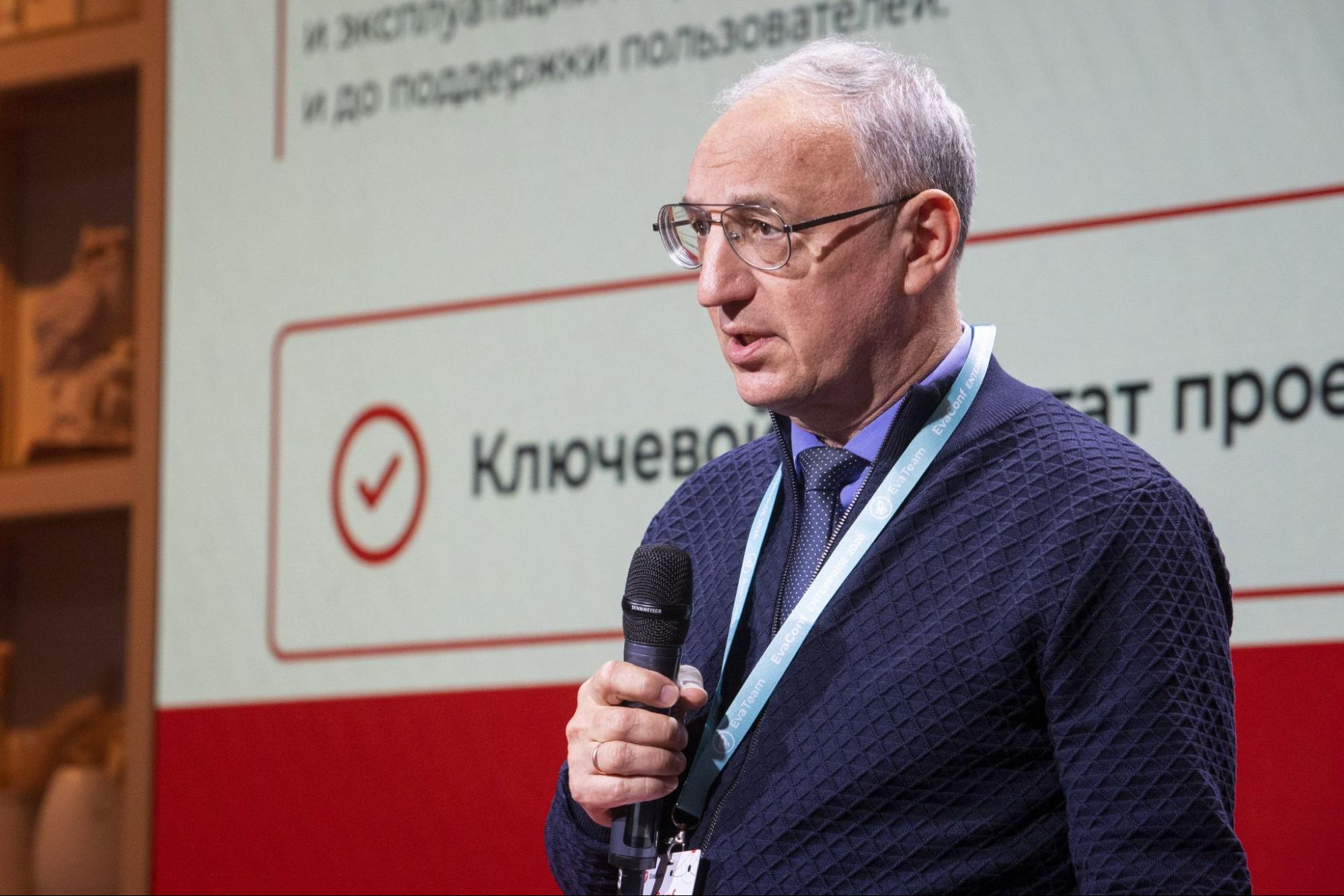 Спикер с микрофоном на фоне слайда о ключевом результате проекта